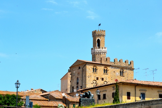 Tower stands tall against the bright Tuscan sky in Volterra